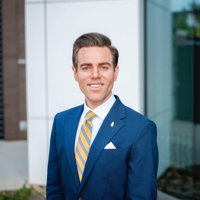 Photo of Sean Holleran, with brown hair and a blue suit